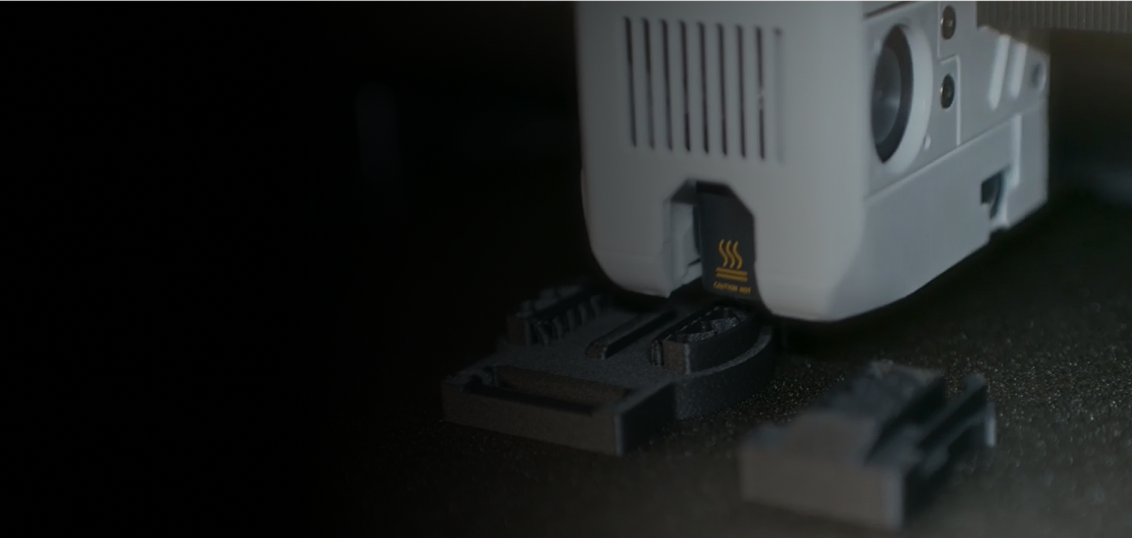 Macro shot of the print head of a desktop 3D printer.
